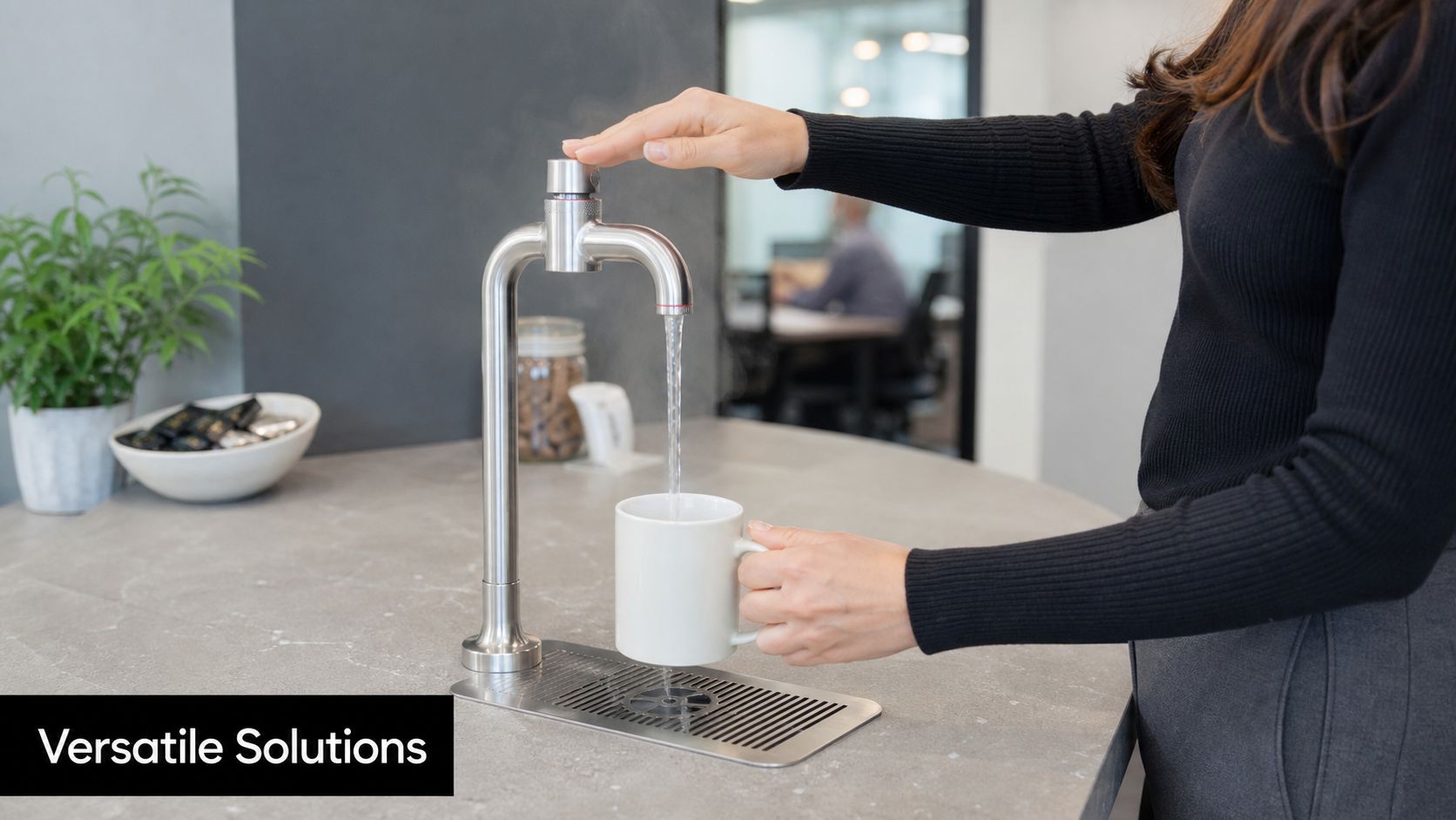 A woman filling a white mug with steaming hot water from a modern stainless steel tap.