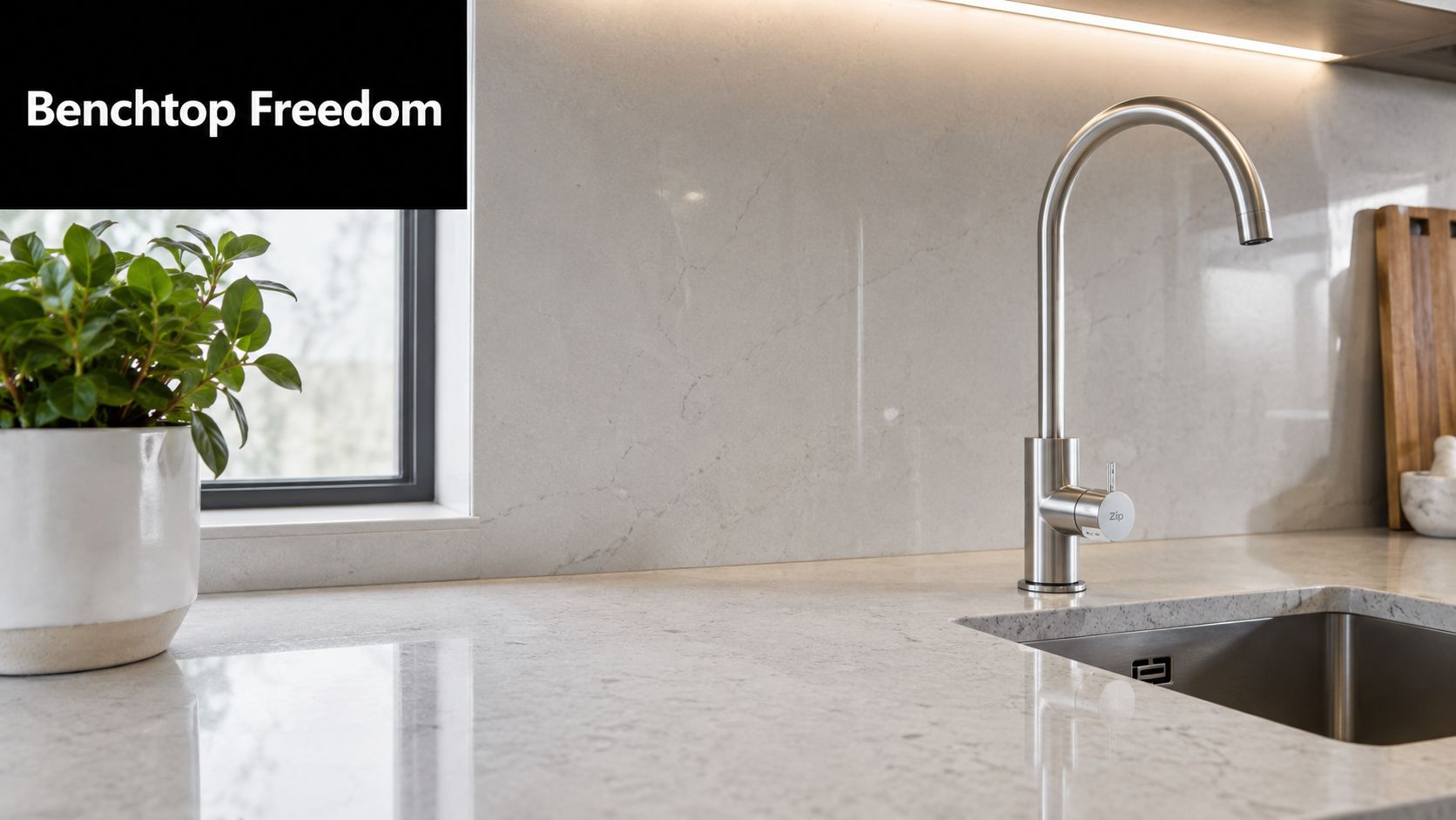 A sleek modern kitchen benchtop with a Zip boiling water tap installed next to a stainless steel sink.